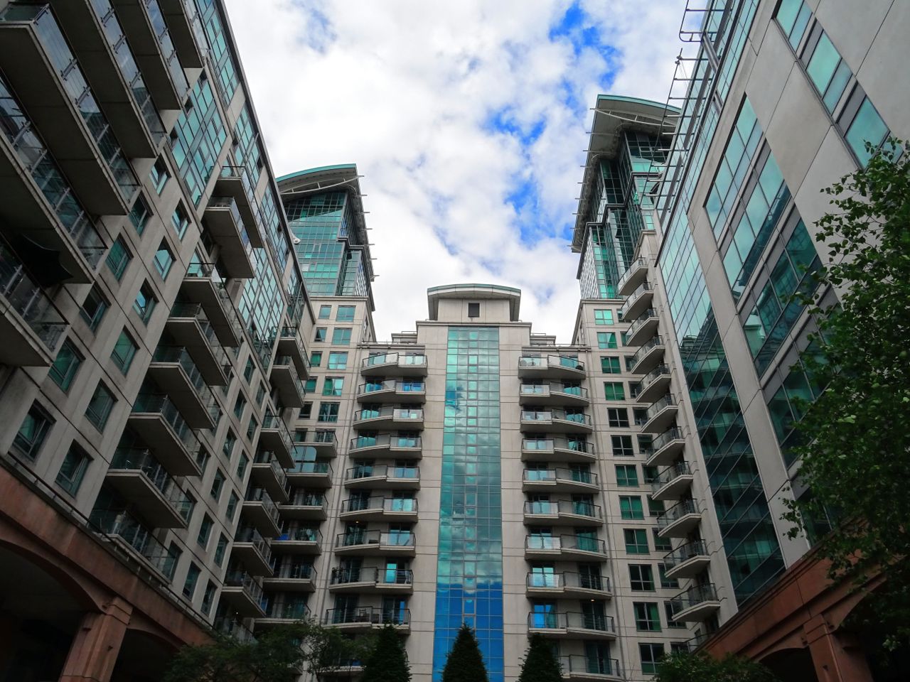 Low angle view of modern glass skyscrapers with a blue sky backdrop, highlighting architectural design.